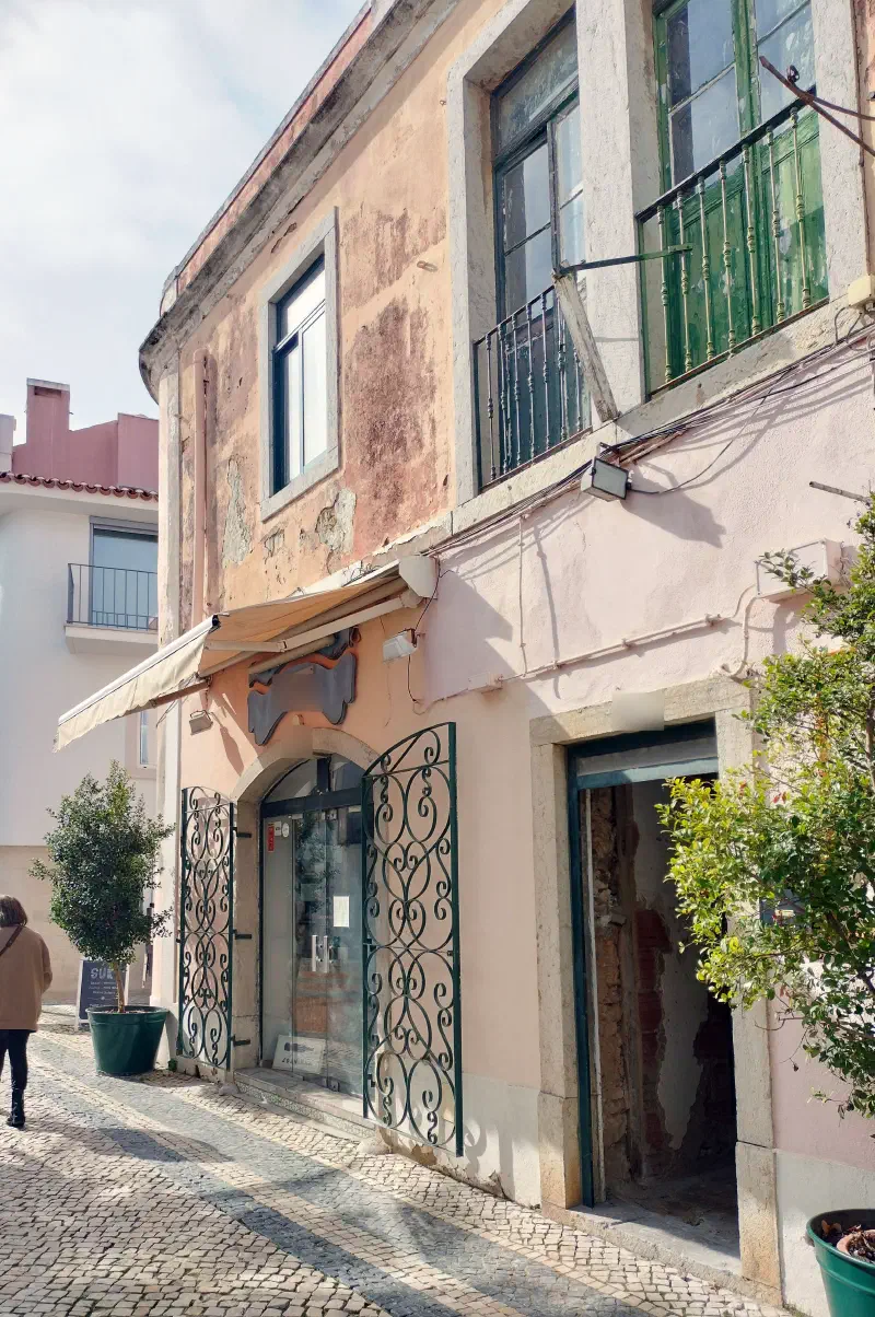 A cobbled street in Cascais lined with traditional Portuguese buildings